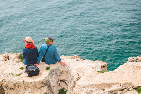 Pula, Croatia - May 21, 2019: senior couple sitting enjoying view of sea bay