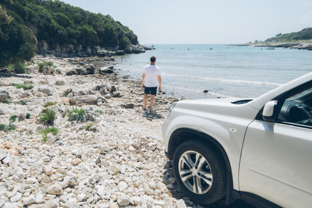car travel concept man at summer beach looking at seaの写真素材