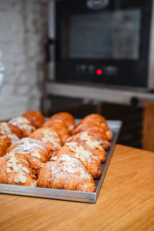 Sprinkle the finished croissants on a baking sheet with almond flakesの写真素材
