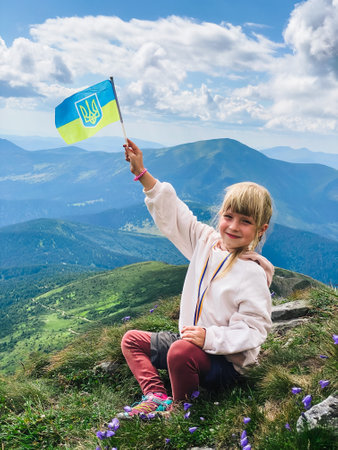 A girl on a mountain with a ukrainian flagの写真素材