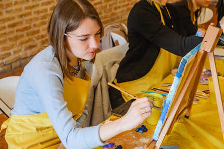 Woman with brush painting on canvasの写真素材