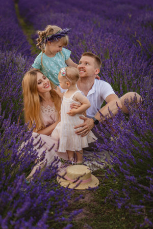 Happy family, father and mother with two daughters on a picnic at lavender fieldの写真素材