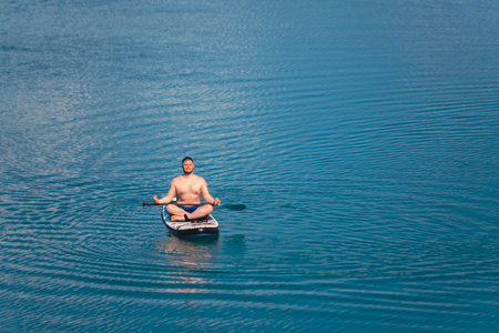 man on paddleboard in the middle of the lakeの写真素材