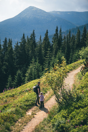 father with daughter at mountain trailの写真素材