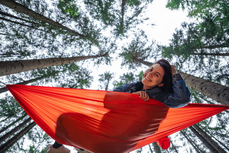 happy woman on hammock in the forestの写真素材