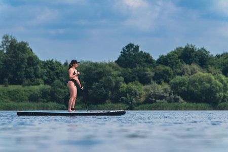attractive woman in swimwear on supboard
