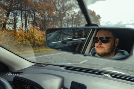 man reflection in car rear mirrorの写真素材