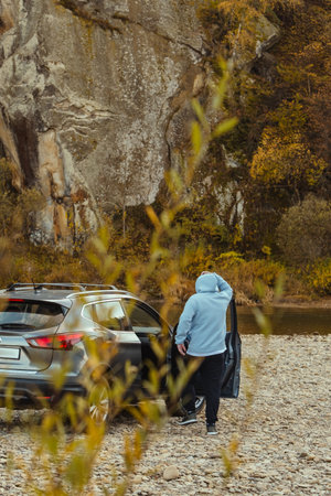 man car traveler stop at river rocky beach enjoying the autumn forest