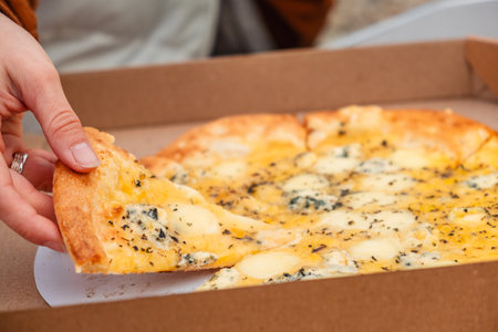 woman hand take peace of pizza close upの写真素材
