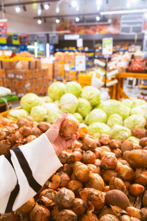 hand taking onion from grocery store shelfの写真素材