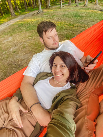 happy couple resting in hammockの写真素材