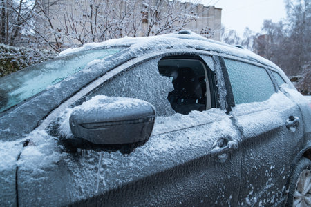 frozen car after snowstorm with broken windowの写真素材