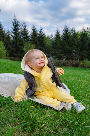 smiling baby boy sitting on a blanket in a spring packの写真素材