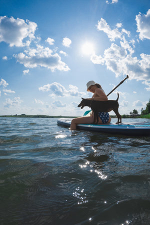 happy woman with dog on supboardの写真素材