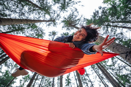 happy woman on hammock in the forestの写真素材