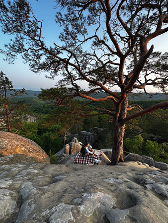 happy couple having date at the cliff on sunsetの写真素材