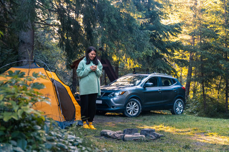 Camping by the Fire in a Serene Forestの写真素材