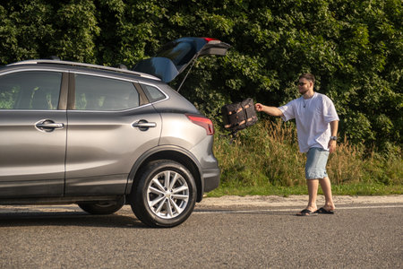 Man with Backpack at Open Car Trunkの写真素材