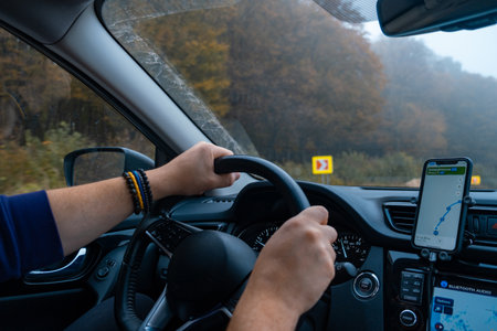 Person Driving by the road at foggy autumn highwayの写真素材