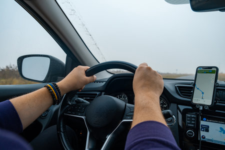 Person Driving by the road at foggy autumn highwayの写真素材