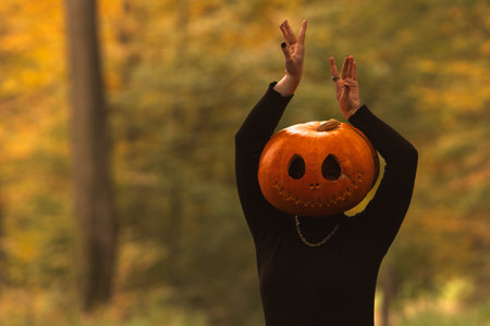 Person in Pumpkin Costume in Autumn Forestの写真素材