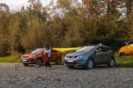 Camping Setup by the Riverbank with Carsの写真素材