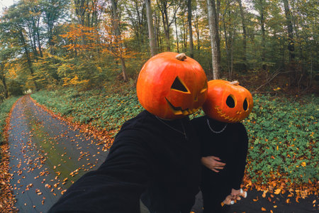 couple taking selfie with pumpkin headの写真素材