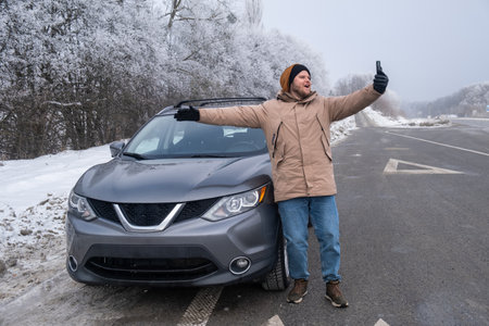 Man Taking Selfie with SUV on Snowy Roadsideの写真素材