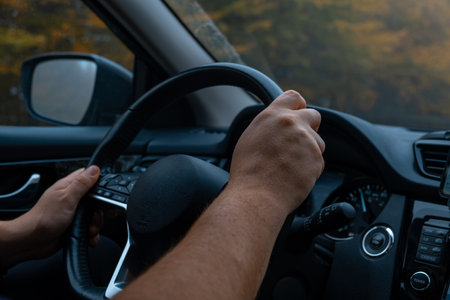 Person Driving by the road at foggy autumn highwayの写真素材