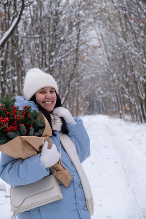 Person Holding Bouquet on Snowy Forest Pathの写真素材