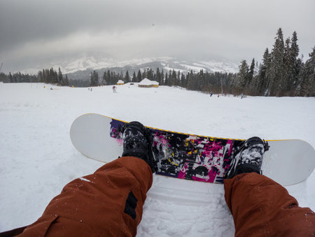 Snowboarding Down a Snowy Mountain Slopeの写真素材