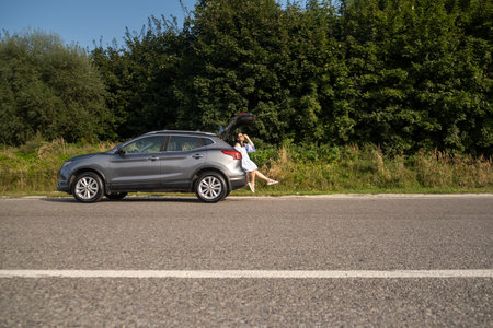 Woman Relaxing on SUV in Natureの写真素材