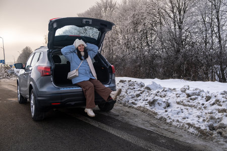 Woman Relaxing in Car on Snowy Roadの写真素材
