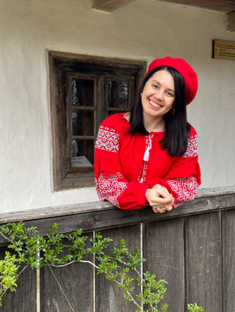 Smiling Woman in Traditional Red Outfit by Rustic Windowの写真素材