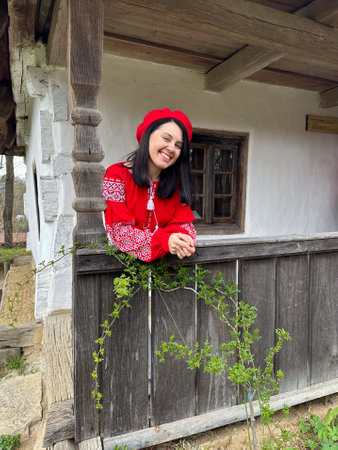Smiling Woman in Traditional Red Outfit by Rustic Windowの写真素材