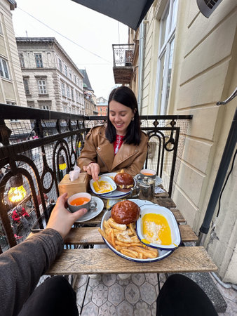 couple Dining on Balcony Overlooking City Streetの写真素材