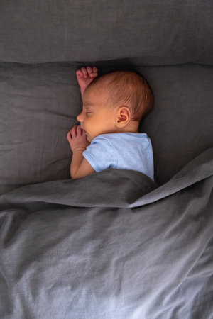 Newborn Baby Sleeping Peacefully on Bedの写真素材