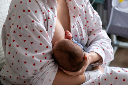 Mother Breastfeeding Baby in Cozy Home Settingの写真素材