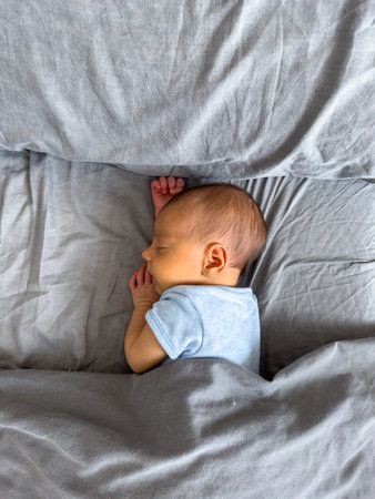 Newborn Baby Sleeping Peacefully on Bedの写真素材