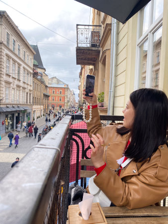 Woman Taking Selfie on European City Balconyの写真素材