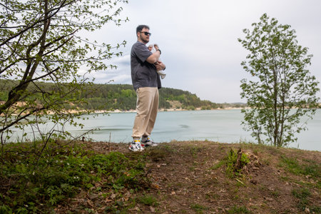 Father Holding Baby by Tranquil Lakeの写真素材