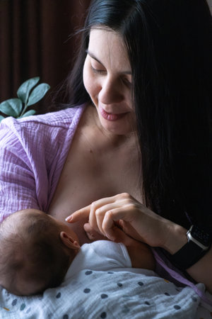 Mother Breastfeeding Baby by Windowの写真素材