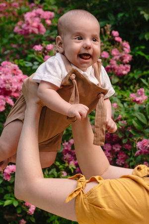 Joyful Mother and Baby in Blooming Gardenの写真素材