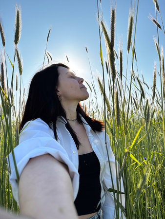 Woman Enjoying Sunlight in a Field of Tall Grass