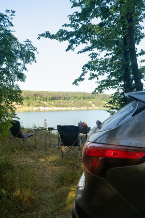 Lakeside Camping Retreat with Car and Chairsの写真素材