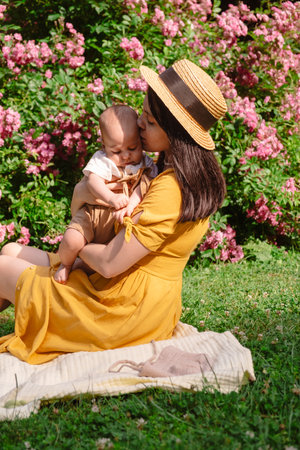 Joyful Mother and Baby in Blooming Gardenの写真素材