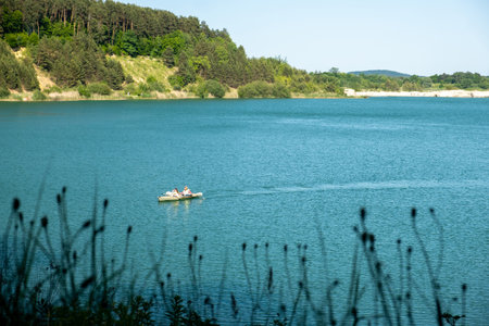 Serene Lake with Boat and Lush Greeneryの写真素材