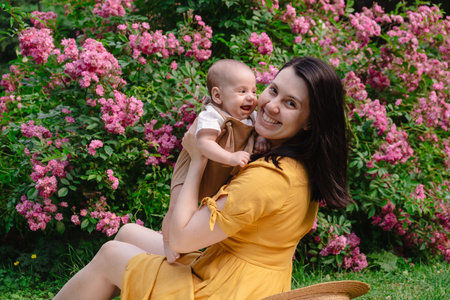 Joyful Mother and Baby in Blooming Gardenの写真素材