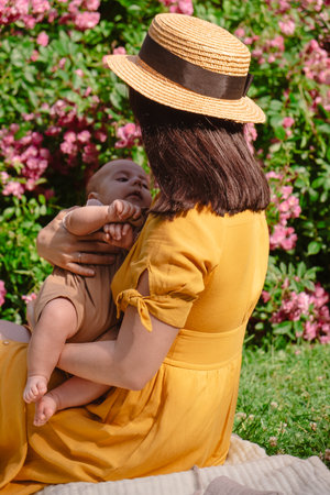 Joyful Mother and Baby in Blooming Gardenの写真素材