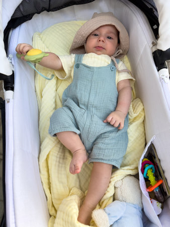 Baby in Stroller with Sun Hat and Toyの写真素材